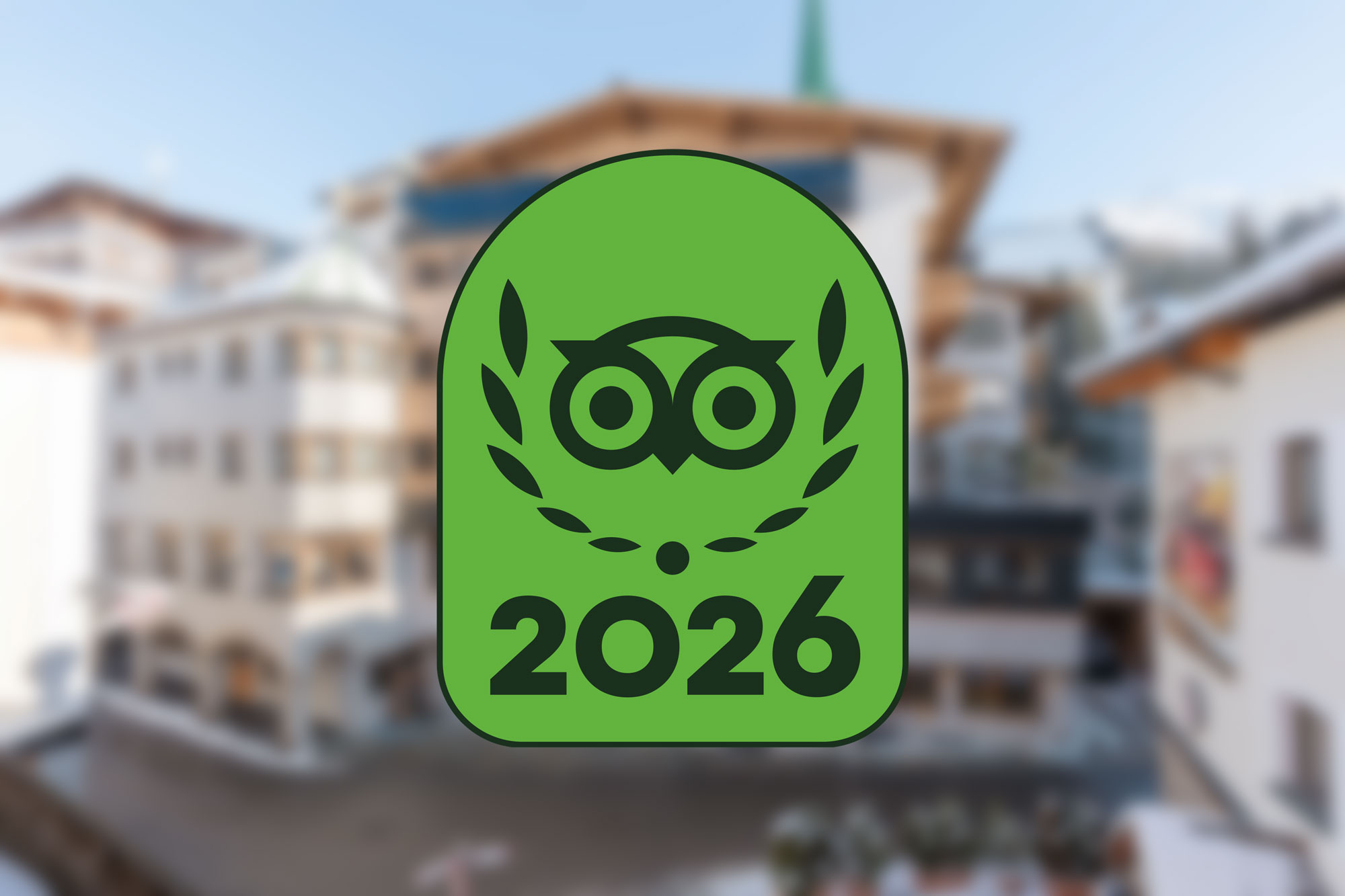 A green badge with an owl and 2026 over a blurred city background.